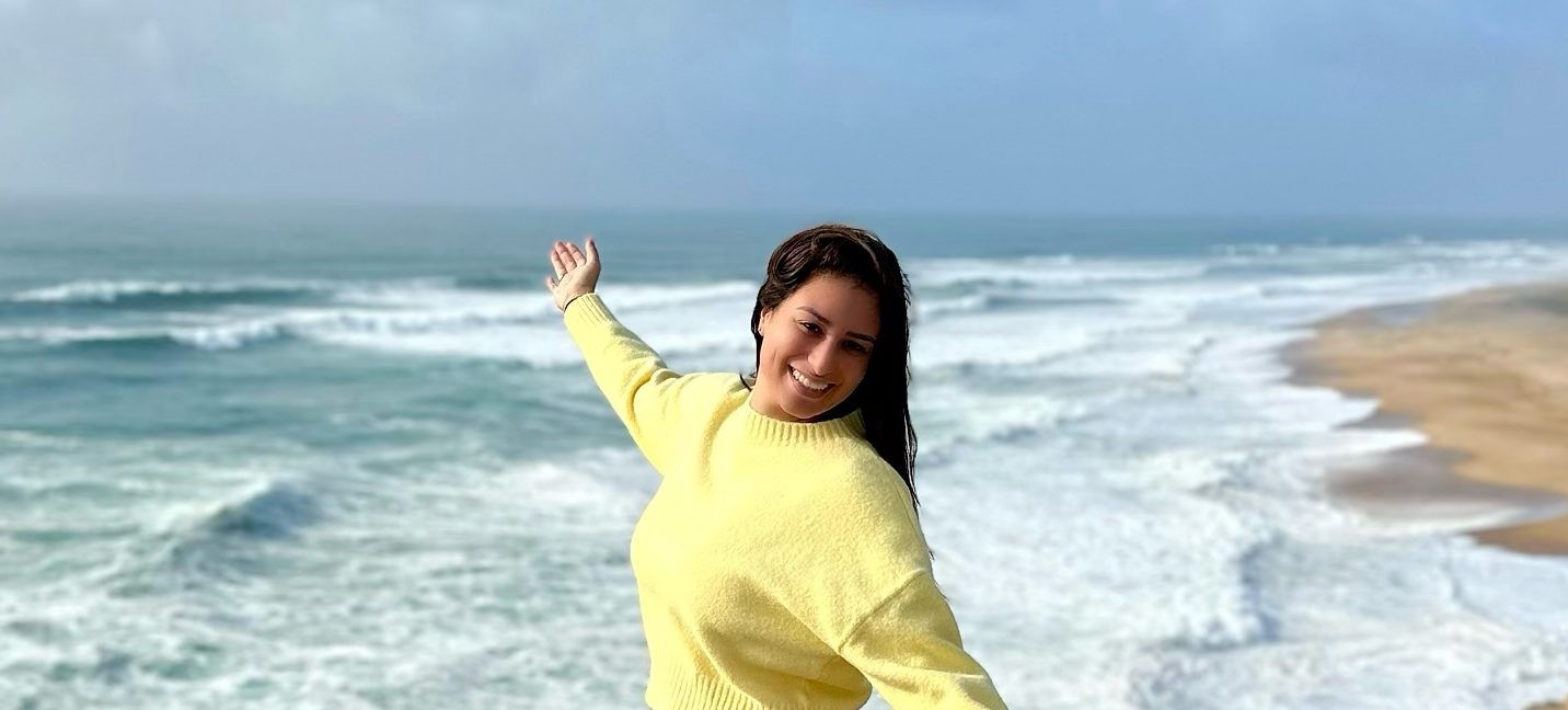 Liz in Nazaré, Portugal, with waves crashing in the background